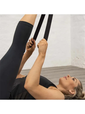 Der schwarze Yoga-Gürtel in Nutzung beim Dehnen