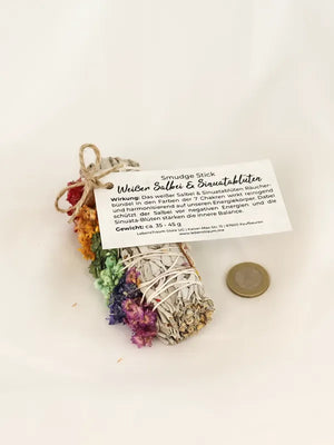 Ein kleines Räucherbündel aus weißem Salbei und Sinuatablüten in den 7 Chakra Farben