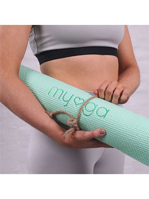 Die hellgrüne Yogamatte zusammengerollt in Arm von einer Frau